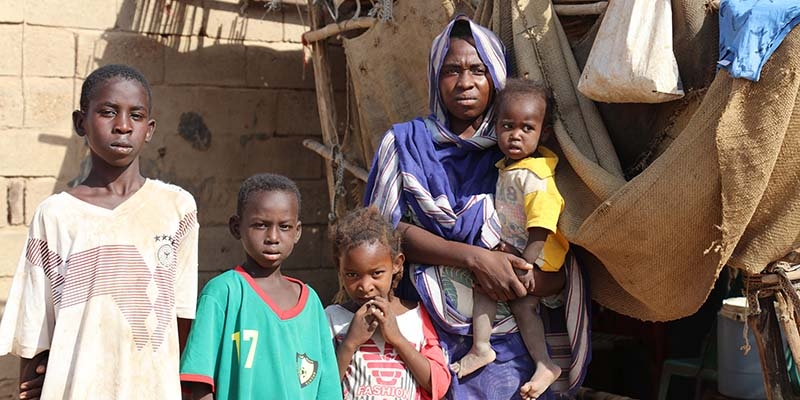 In Sudan, a family stands near their home in an area of the country that has been impacted by severe economic crisis and hyper-inflation in Sudan.