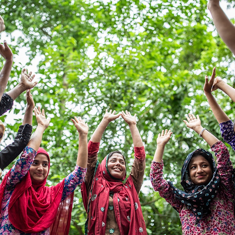 Young women in Bangladesh raising their hands over their heads