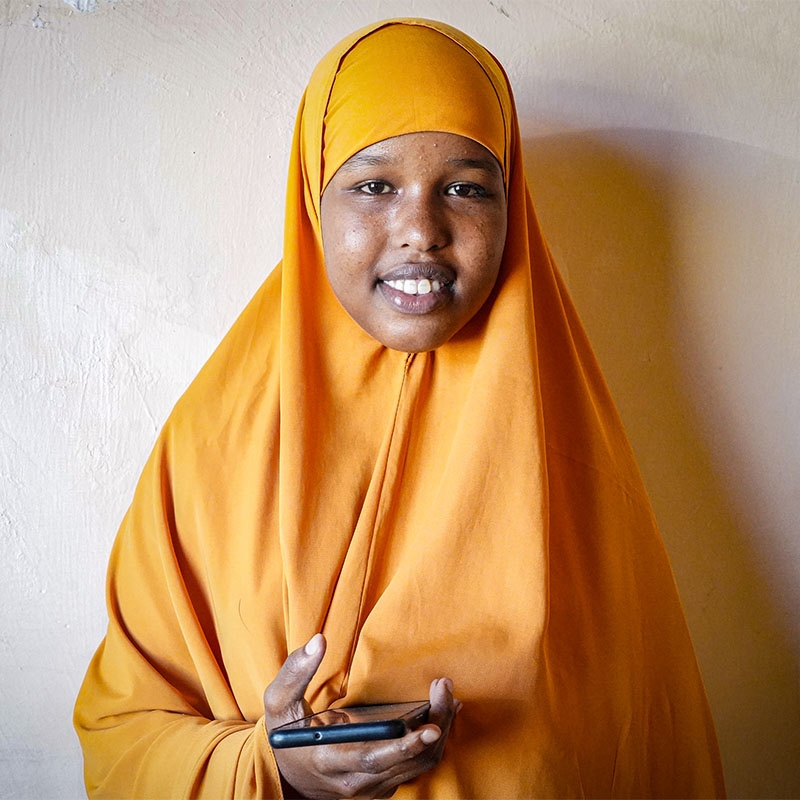 A teenager in Somalia holds a smartphone