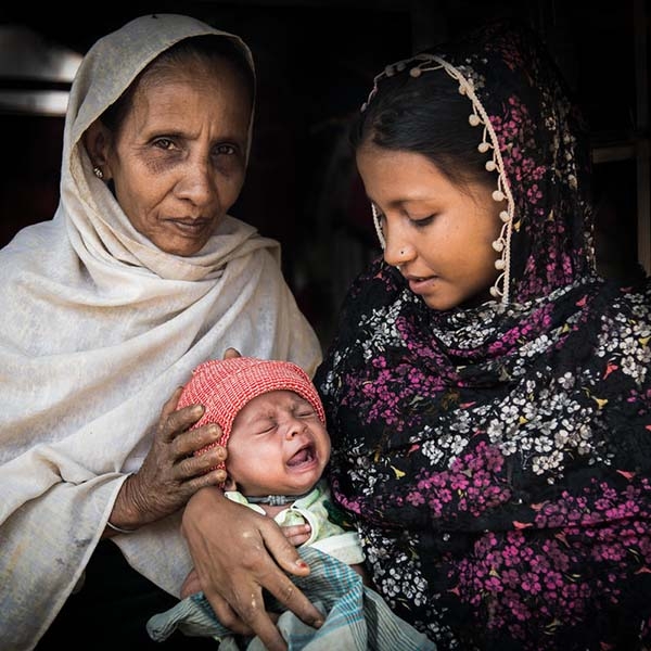 A four-month old baby is held by his mother and grandmother, both Rohingya refugees, in Cox's Bazar, Bangladesh.