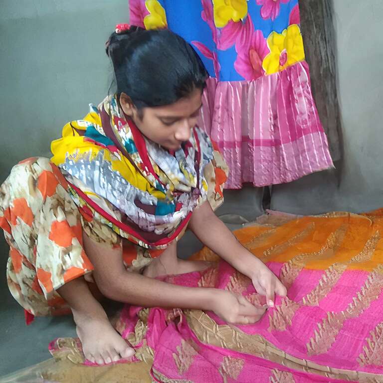 Young girl sewing a pink and gold mat