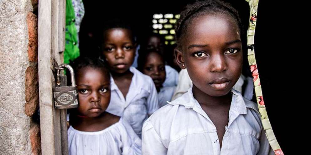 Girls stand in the doorway of their school in the Democratic Republic of Congo - a country facing one of the worlds largest humanitarian crisis