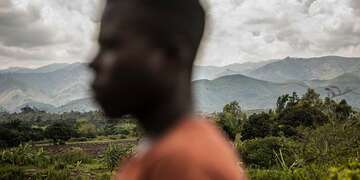 The face of a boy is blurred against the backdrop of a vast landscape in DRC