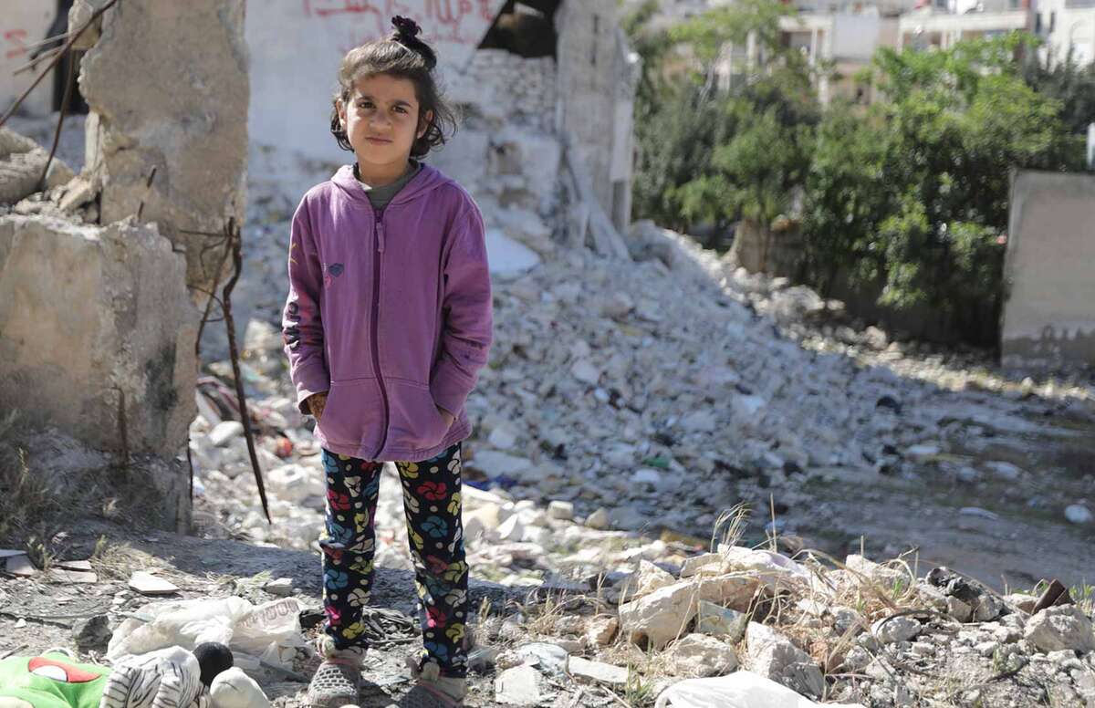 A child stands amongst the rubble in North West Syria