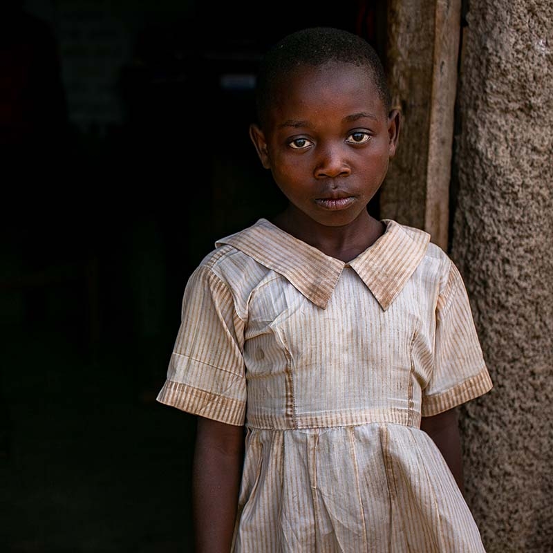 Uganda, a little girl in a doorway in a refugee settlement