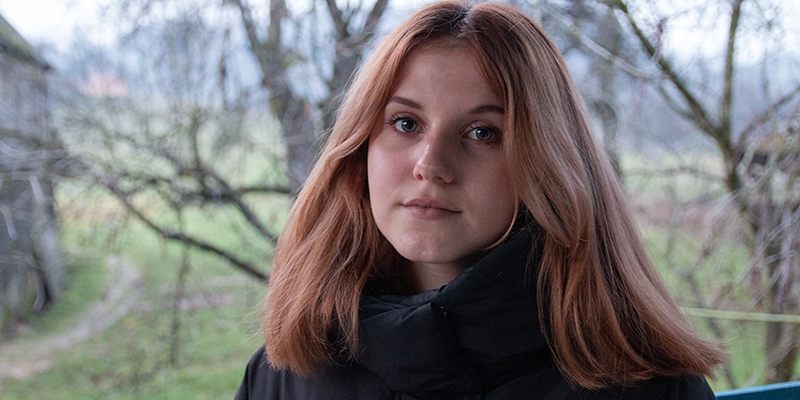 Ukraine, a teenage girl looks straight to the camera wearing a black winter coat