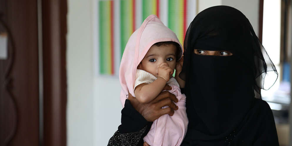A mother holds her baby in Yemen