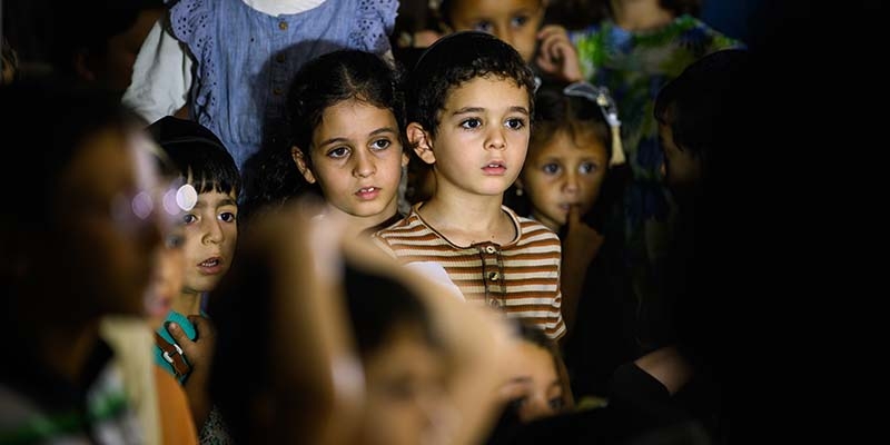 In Israel, children watch a puppet show. 