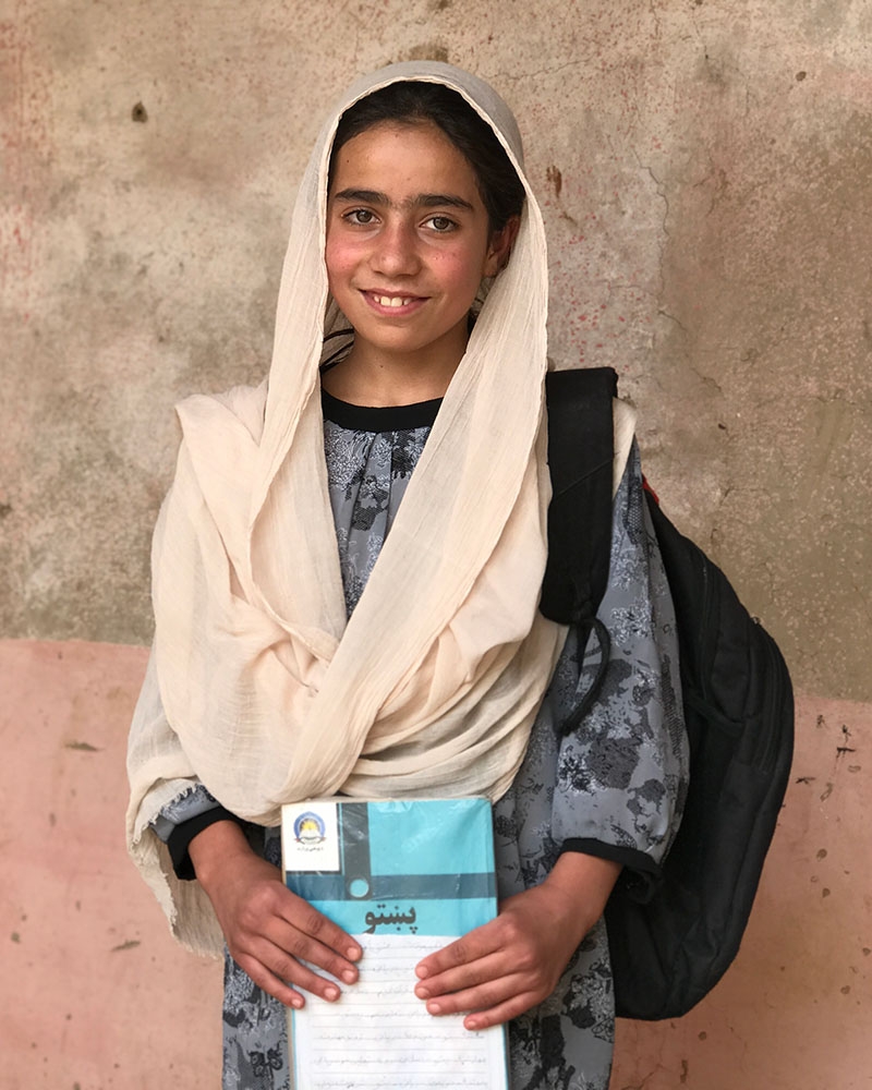 A girl in Afghanistan holds a notebook