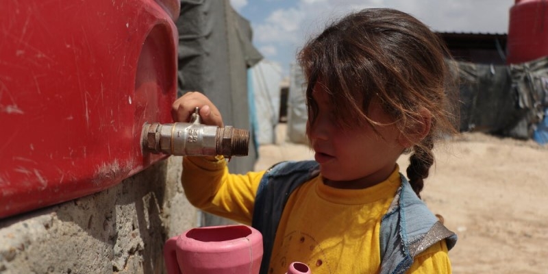 Zaina,* 6, fetches water from a tank in Al Hol camp, north east Syria in August 2021. Zaina’s* mother sold food rations to buy her bottled water after Zaina* got sick from drinking poor-quality water.  *Name changed. Credit: Muhannad Khaled / Save the Children