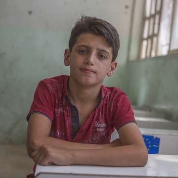 A 12-year-old student sits in his school in West Mosul, which was damaged extensively during the fighting between Iraqi forces and ISIS. Photo credit: Sam Tarling/Save the Children 2018.