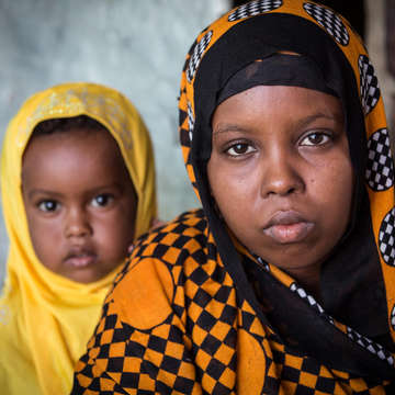  Aisha*, 15, former child bride, with her two year-old daughter Rayan*.  Photo credit: Colin Crowley / Save the Children
