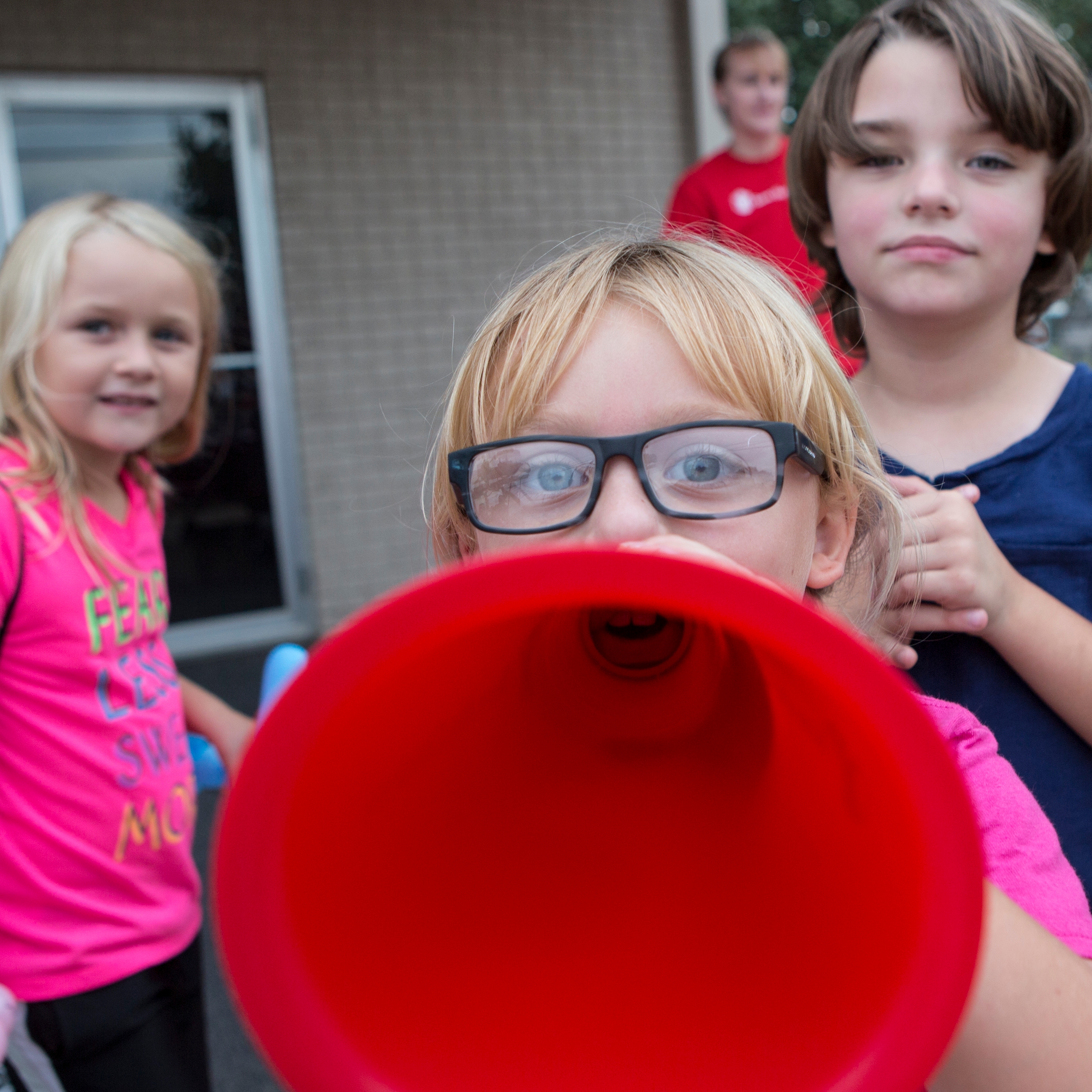 Children play outdoors with a megaphone at a celebration for the 20th anniversary of Agapeland Learning Center, in Moore, OK. In 2013, Save the Children helped reopen the center after a tornado ripped the roof off the building while children and teachers sheltered inside. Photo credit: Brett Deering/Save the Children, September 2016.