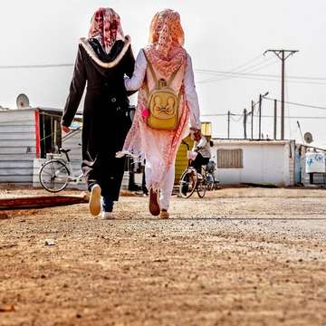 Two anonymous girls walk through the Za'atari refugee camp in Jordan Photo credit: Eric Atkinson / Save the Children 2019.