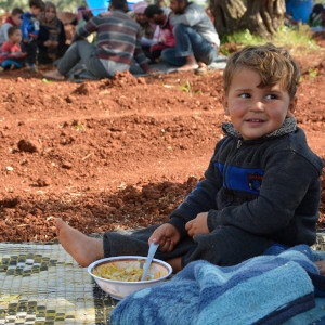 A child eats at a temporary camp for those who have fled fighting in Idlib, Syria, May 2019. Over 180,000 people have escaped an upsurge in violence in Idlib over the last few weeks. Credit: Save the Children. 
