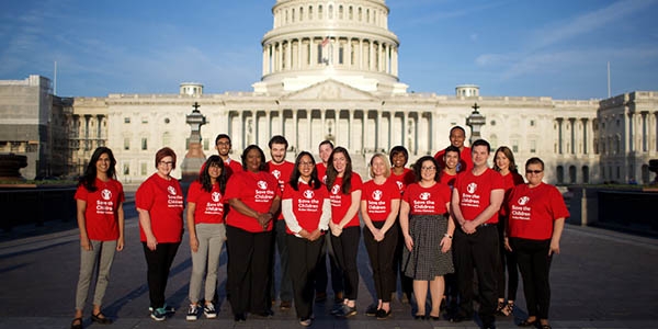 A group of Save the Children advocates stand in front of the capital . 
