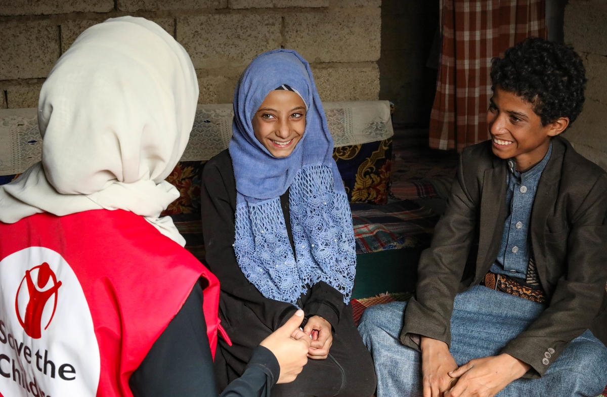 Yousuf*, 13, and his younger sister Sumaia*,10  are pictured with a Save the Children worker in Yemen in August 2019. Yousuf* was injured in an explosion, and Sumaia*  spoke to Save the Children about her fears of her siblings getting injured again. *Names have been changed. Credit: Antonia Roupell/ Save the Children.