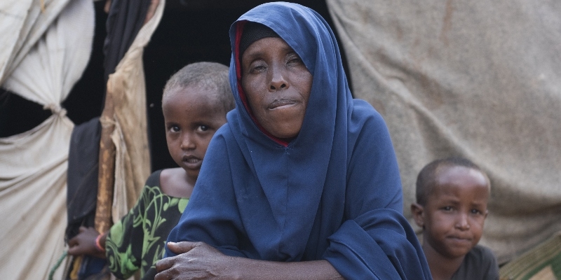 a mom and her daughter and granddaughter sit together in a displacement in south somalia