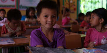 A boy sits in a full classroom in Vietnam.