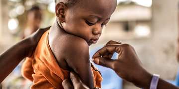 A one-year-old child prepares to receive his Yellow Fever vaccination in the Democratic Republic of Congo. Photo Credit: Tommy Trenchard, August 2016.