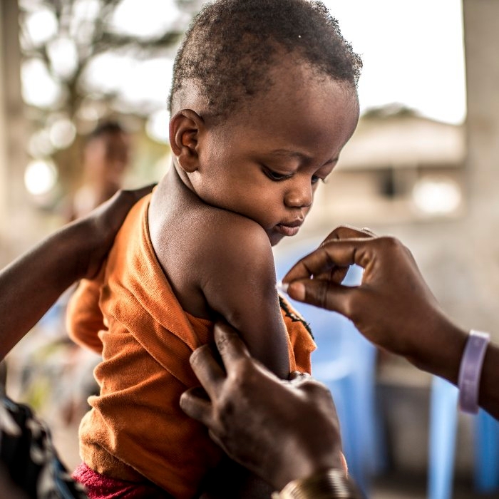 A one-year-old child prepares to receive his Yellow Fever vaccination in the Democratic Republic of Congo. Photo Credit: Tommy Trenchard, August 2016
