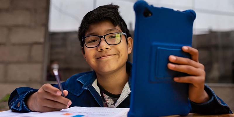 Peru, a Child Campaigner for Education holds a blue tablet.