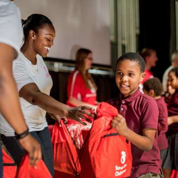 Volunteers hand out emergency go-bags to students at a Prep Rally at Speedway Academies in Newark, N.J. A Prep Rally is an interactive program that helps teach children critical disaster preparedness skills – it’s a signature part of our Get Ready, Get Safe initiative. This Prep Rally was held in October of 2017 to mark the fifth anniversary of Hurricane Sandy. Photo credit: Susan Warner/Save the Children, November 2017.