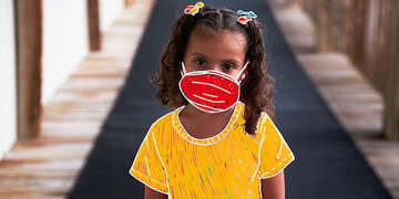 A girl stands with an animated mask on. 