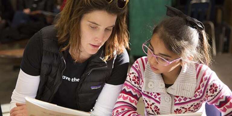 Cobie Smulders reads a book with a child participating in Save the Children's U.S. programs.