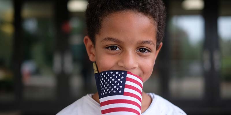 A boy holds an American flag