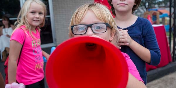 A girl holds a megaphone up to her face.