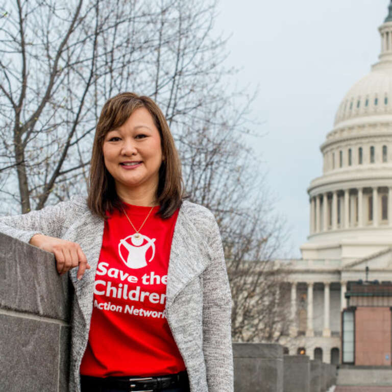 A Save the Children Action Network advocate stands in front of the Capitol Building in Washington D.C.