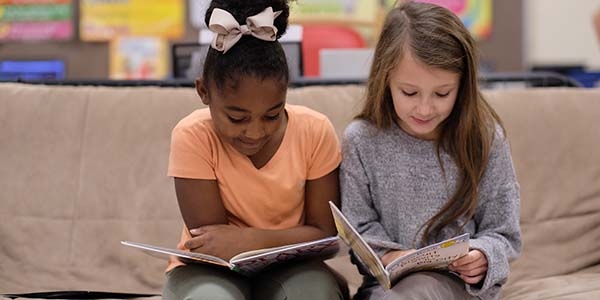 Taylor, age 7, left, and classmate Tara, age 8, read together during Save the Children's Guided Independent Reading Practice at their school in Tennessee.