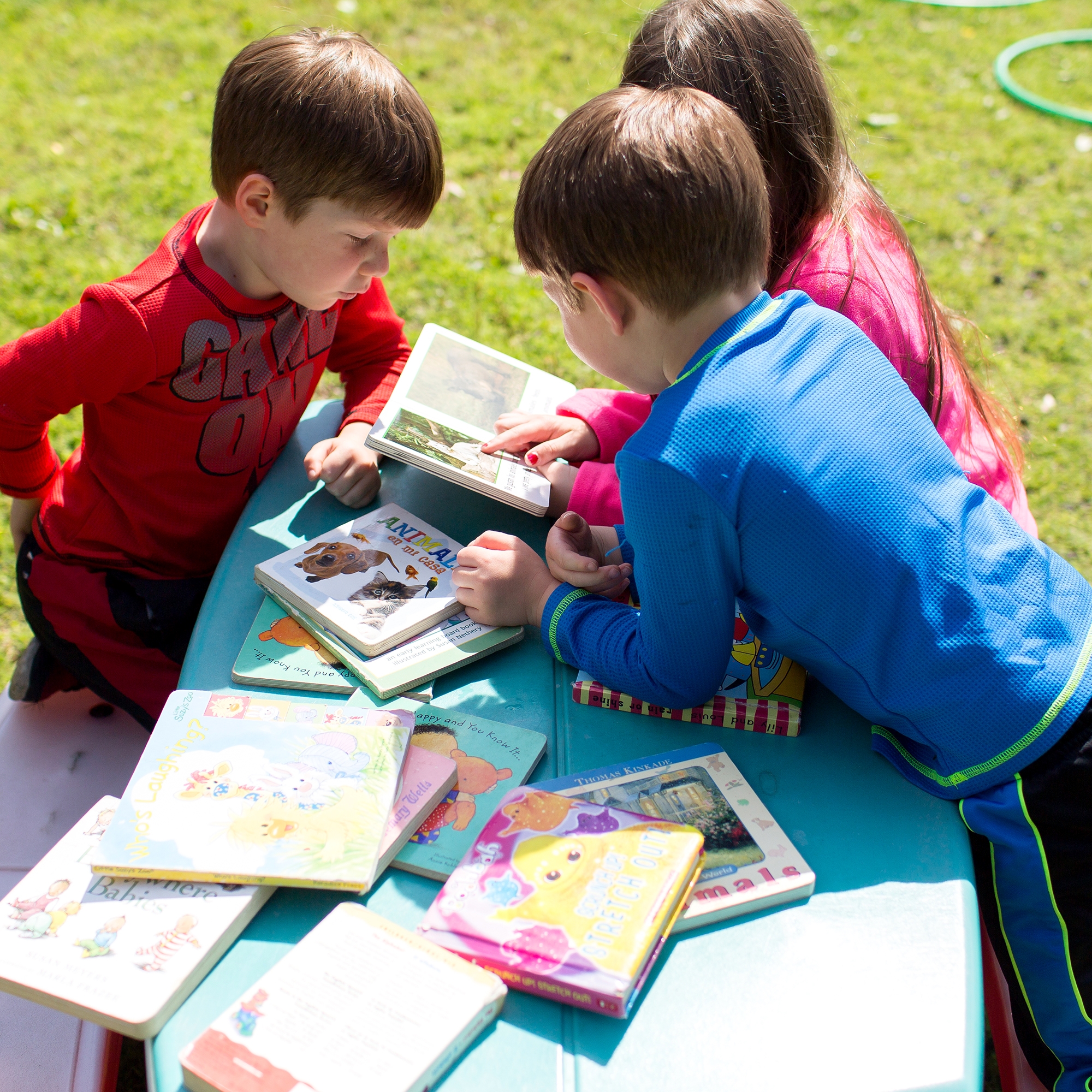 Easton, Kellen and Ada share a book on the playground at Save the Children’s Head Start center in Arkansas, on April 27, 2017. Photo credit: Eli Murray / Save the Children 2017.