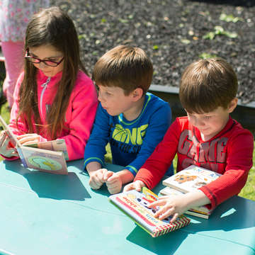 Ada, Kellen and Easton look at books on the playground at Save the Children’s Head Start center in Russellville, Ark., on April 27, 2017. Save the Children brings its expertise in improving educational opportunities and outcomes for kids in underserved communities to its federally-funded Head Start and Early Head Start programs, which promote school readiness and social and emotional development for kids in low-income families. Photo credit: Eli Murray / Save the Children 2017.
