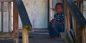 A young boy sits on the porch of his home in Tennessee. 