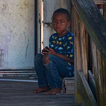 A young boy sits on the porch of his home in Tennessee. 
