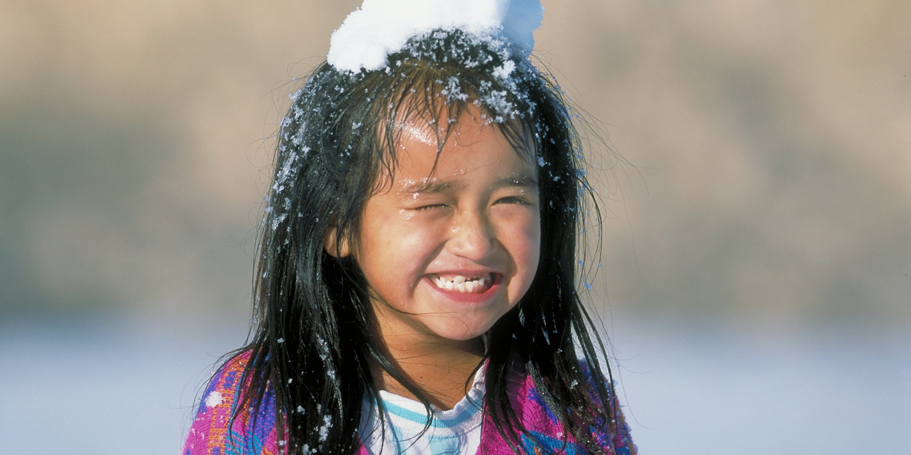 A girl plays outside in the snow