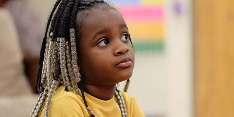 A young girls looks seriously into the distance while sitting in a classroom in Tennessee.