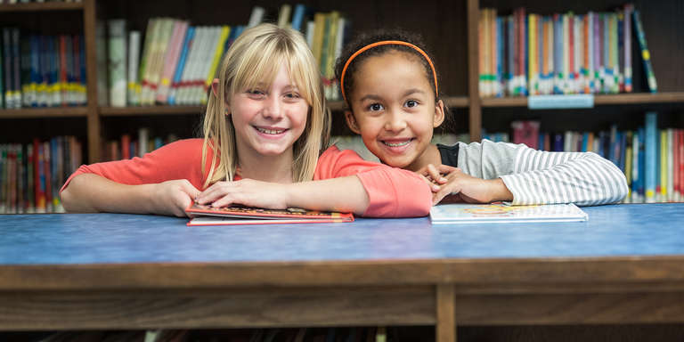 Two third-grade girls, Madison and Justine, smile in the school library at the Save the Children-sponsored afterschool literacy program. The program is held in their elementary school in West Virginia. Photo credit: Susan Warner/Save the Children, February 2015.