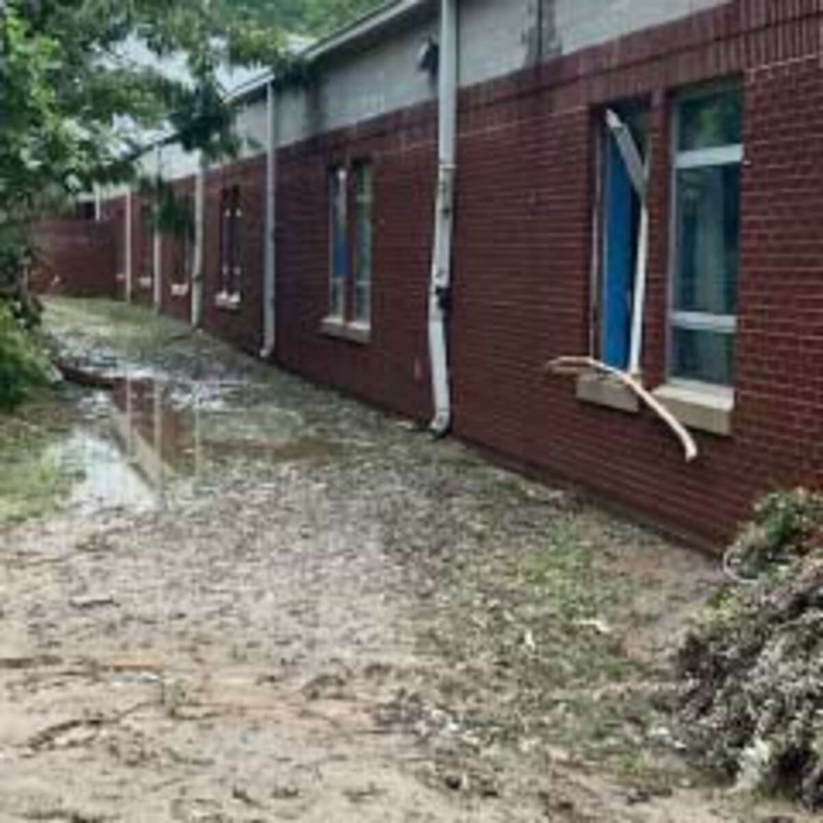 Flood waters from the Kentucky floods are rising up against a red brick building. 