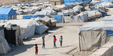 A group of children stand together in a road surrounded by tents in a camp in North East Syria, the area where Turkey has launched a military operation. As a result of the hostilities, already vulnerable families are being forced to flee for safety. Save the Children is working in the three camps to provide much-needed humanitarian aid and support, including tents and food. Photo credit: Save the Children, Oct 2019.