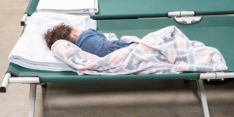 A child sleeps on a cot in a Save the Children-supported transit center at the U.S.-Mexico border.