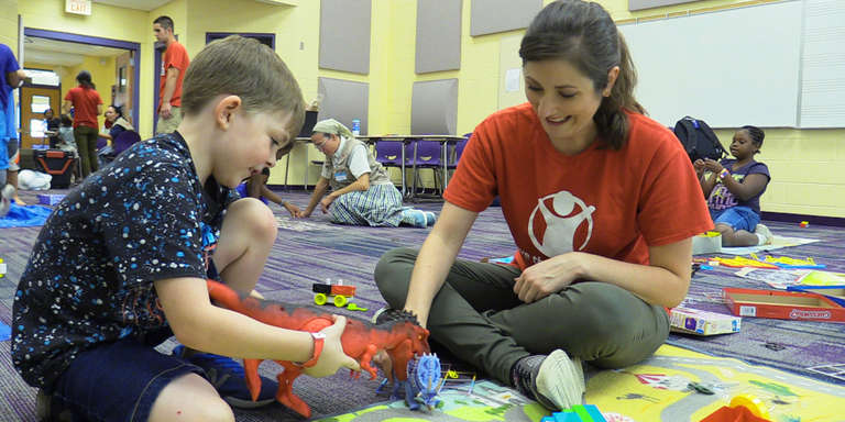 A Save the Children Volunteer playing with a child in a hurricane shelter.  