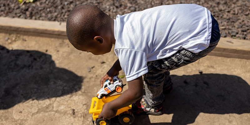 California, a little boy plays with his toy truck and dump truck.