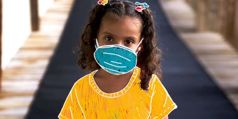 A young girl with a line art graphic of a yellow shirt and blue mask. 