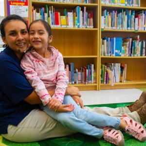 Consuelo sits with her mom, Luz, in the library at her southwest Florida child care center. Consuelo participated in Save the Children's Journey of Hope resilience program in the aftermath of Hurricane Irma, which helps children and caregivers cope with traumatic events, develop their natural resiliency and strengthen their social support networks. Journey of Hope has helped kids across the state of Florida cope with stress and anxiety following the catastrophic 2017 storm. Save the Children, June 2018.