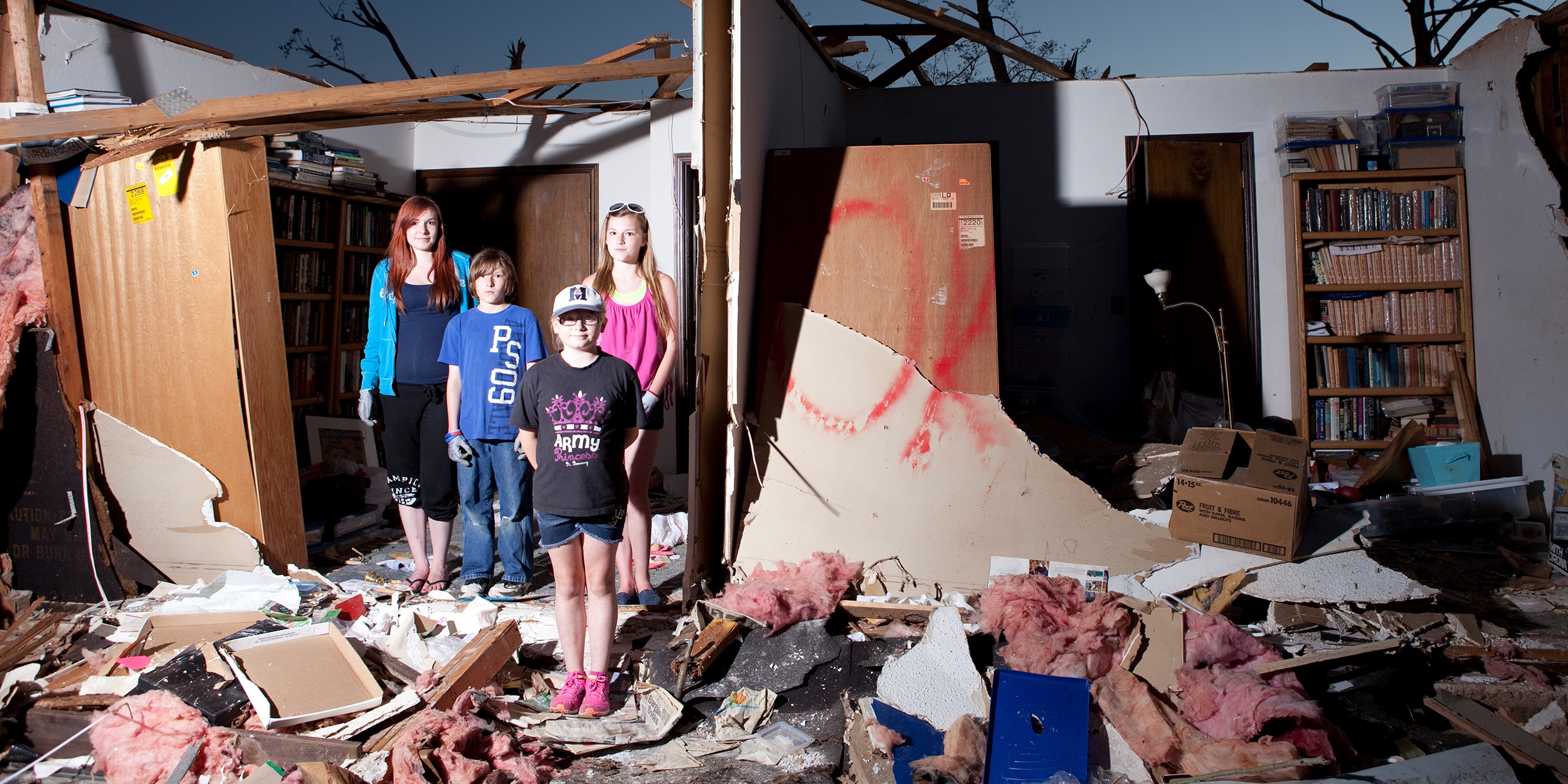 A group of children stands amid the debris that was once their grandmother’s home after an EF5 tornado hit Moore, Oklahoma in May of 2013.