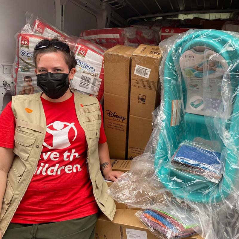 A Save the Children team member stands next to a truck filled with supplies to help children and families impacted by Hurricane Ian in Florida. 