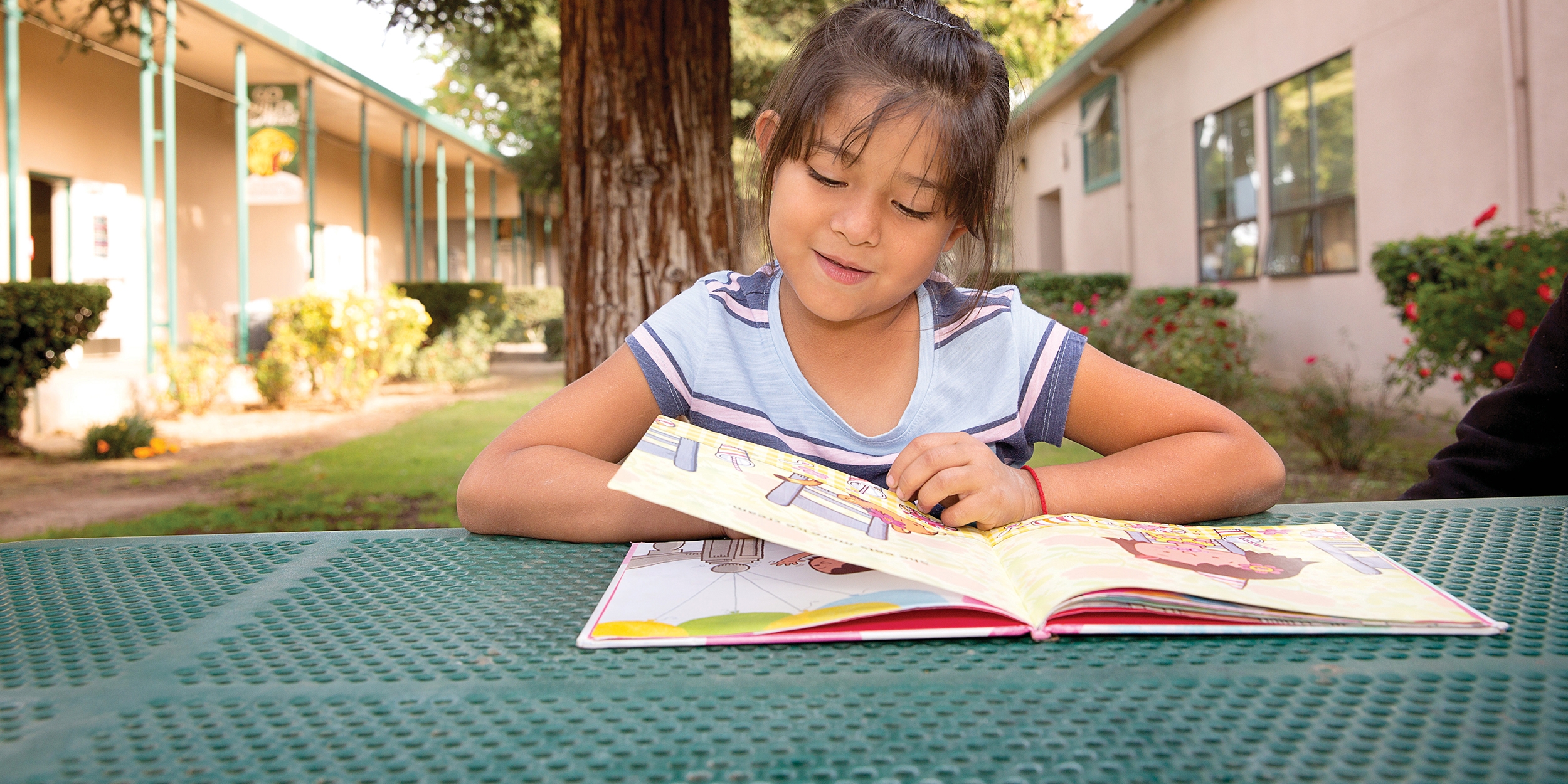 7-year-old Stephanie flips through the pages of a book during one of Save the Children’s after-school programs in Central Valley, California. The program gives students opportunities to strengthen their literacy skills, get support with homework and participate in physical activities that combine fitness and fun. Photo credit: Tamar Levine/Save the Children, November 2017.